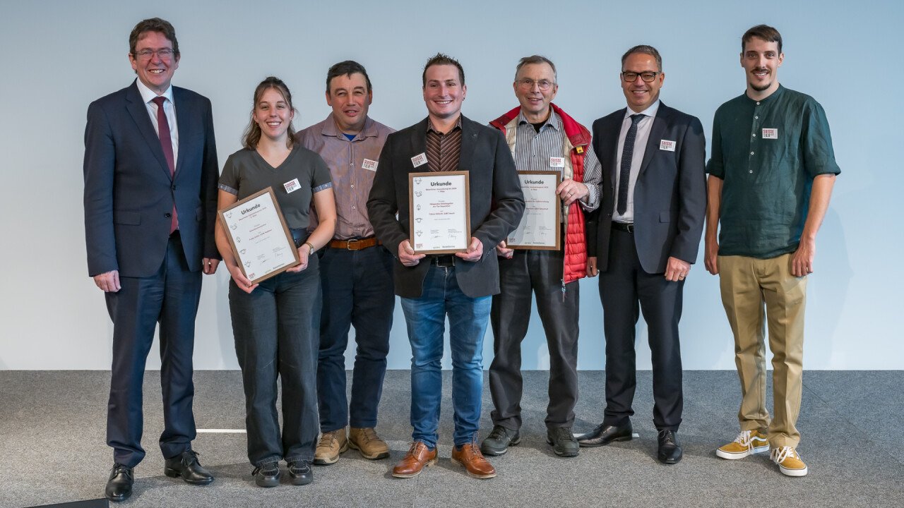 Die Gewinner der bäuerlichen Innovationen flankiert von (von links) Bundesrat Albert Rösti, Präsident des Messebeitrats Meinrad Pfister und Moderator Livio Janett.