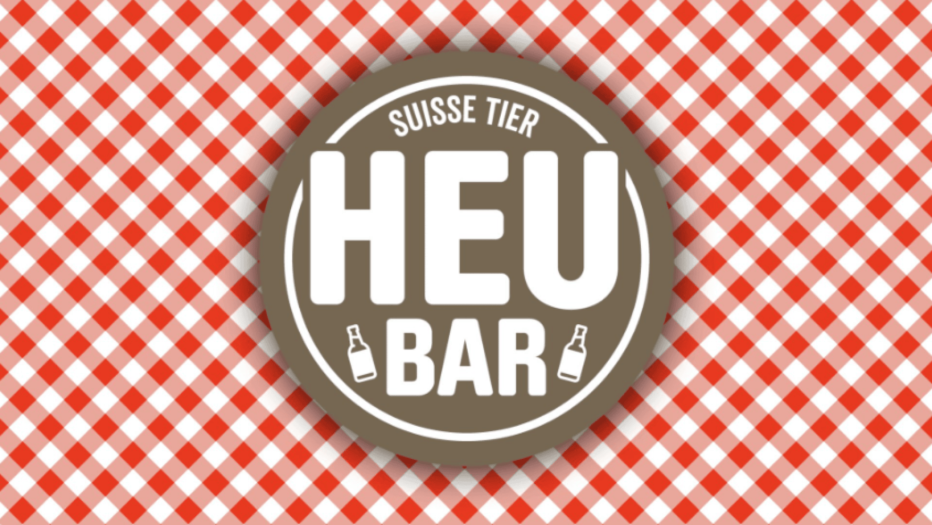 Ein rundes braunes Logo mit dem Schriftzug SUISSE TIER HEU BAR in Weiß und zwei kleinen Flaschensymbolen. Der Hintergrund besteht aus einem rot-weiß karierten Muster.