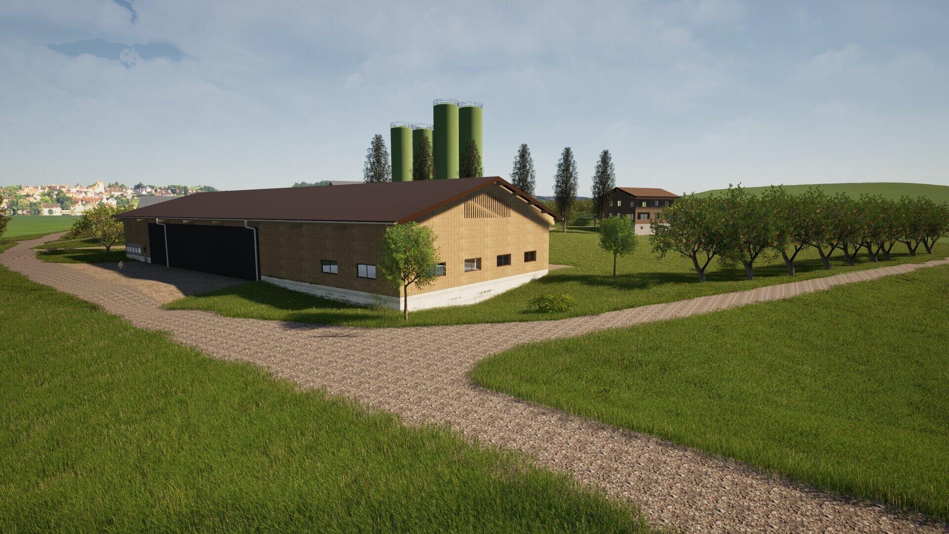 Eine große Scheune mit einem braunen Dach steht neben einem Feldweg, umgeben von grünem Gras und Bäumen. Drei hohe grüne Silos und ein weiteres Gebäude sind im Hintergrund unter einem teilweise bewölkten Himmel zu sehen.