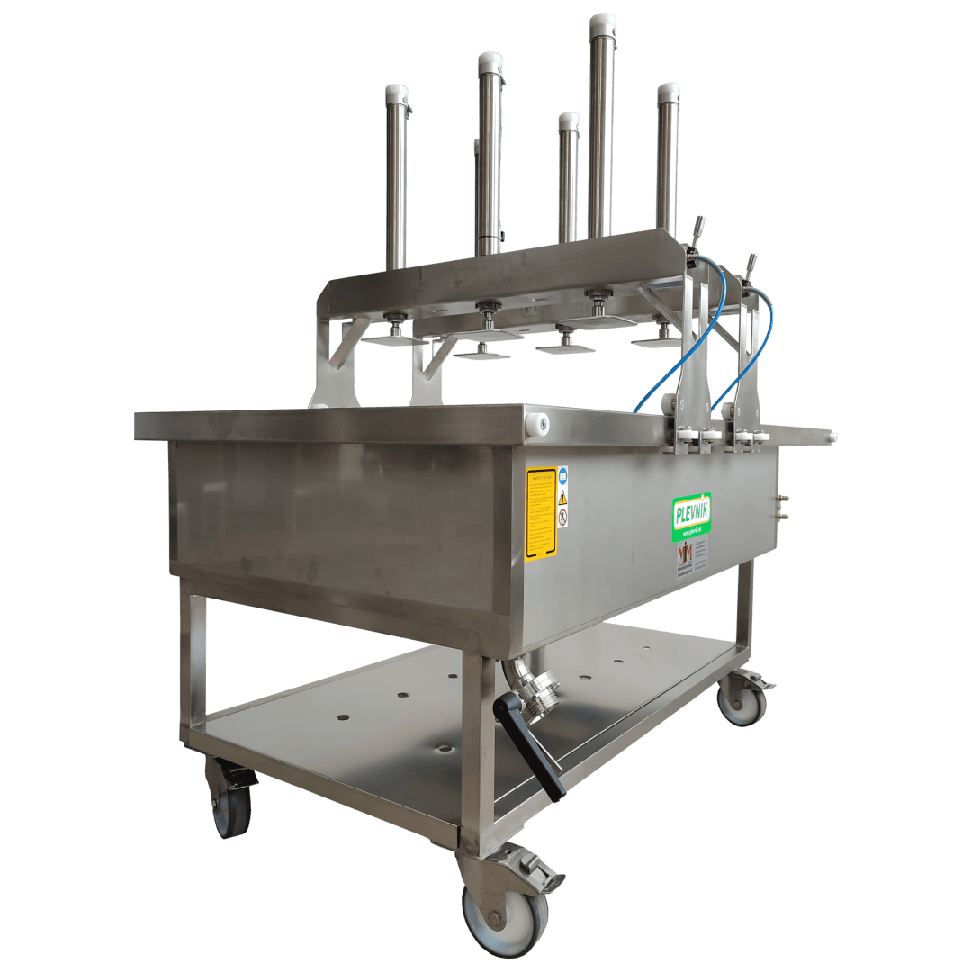 Eine große Industriemaschine aus rostfreiem Stahl mit vier vertikalen Kolbendosierern an der Oberseite, die auf Rädern montiert und mit Fleximan beschriftet sind. Er verfügt über Steuerventile, Warnschilder und einen Ablassstutzen.