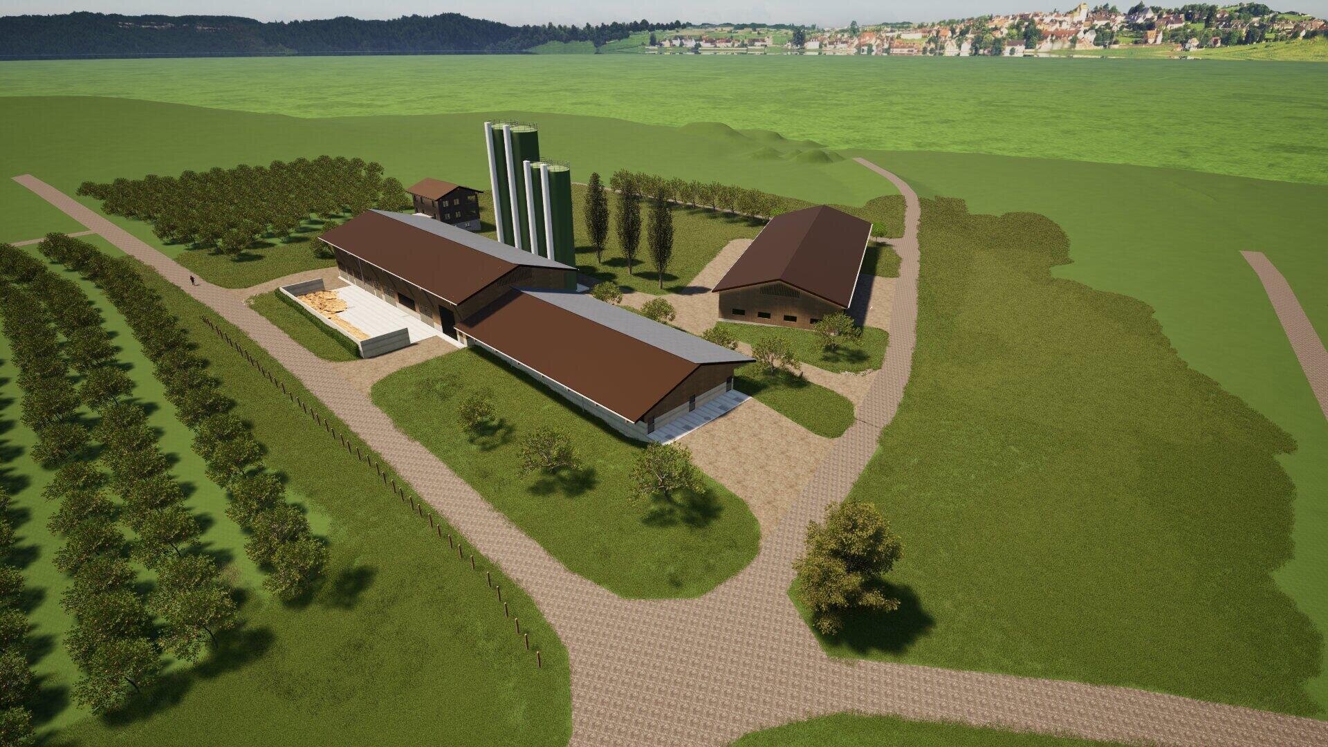 Luftaufnahme eines modernen Bauernhofkomplexes mit mehreren Gebäuden mit braunen Dächern, Silos, Bäumen und Wegen inmitten einer grünen Landschaft mit einem entfernten Dorf und Hügeln.